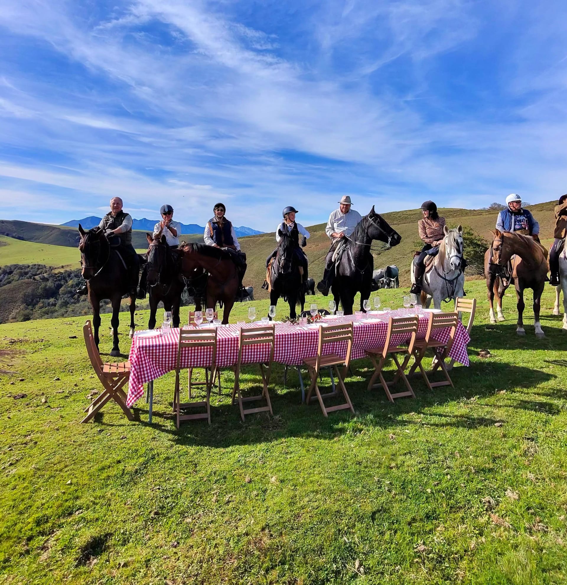 Riders and a laid table on the high valley, the Picos behind